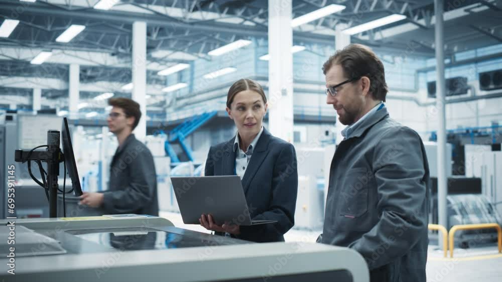 Caucasian Female Manager Using Laptop And Talking To Male Industrial Engineer At Modern Electronics Factory. Colleagues Using Soldering Jet Printer For Super Computer Motherboards Production. Caucasian Female Manager Using Laptop And Talking To Male Industrial Engineer At Modern Electronics Factory. Colleagues Using Soldering Jet Printer For Super Computer Motherboards Production.