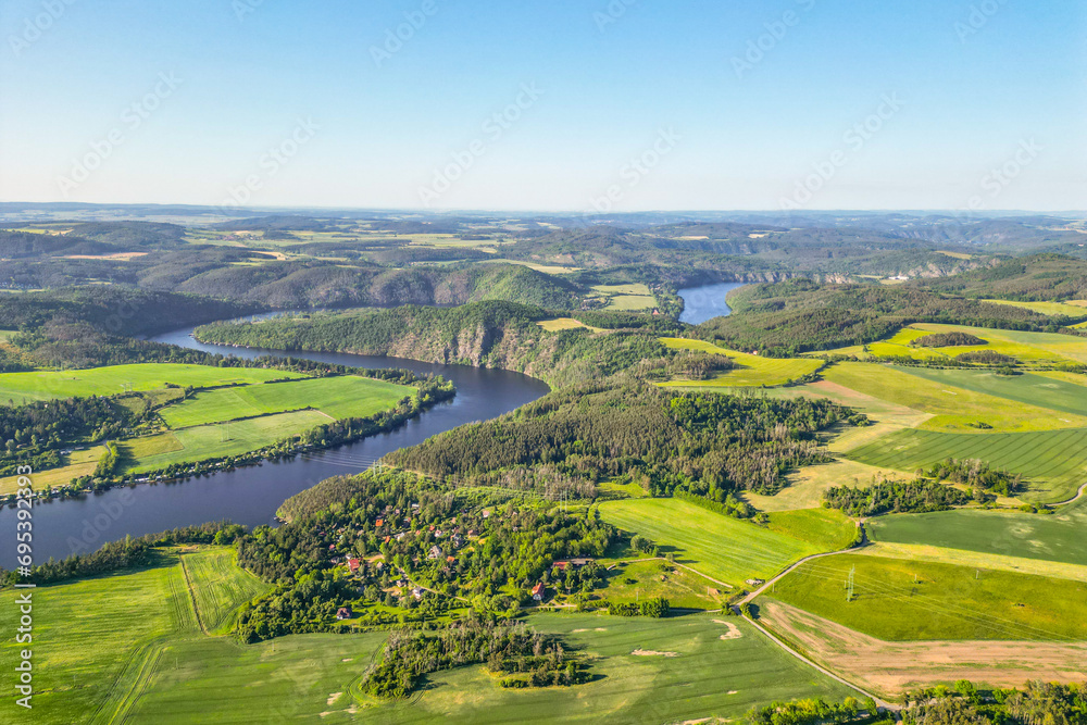 Curves of Vltava river in green landscape on sunny summer day. Aerial drone view.