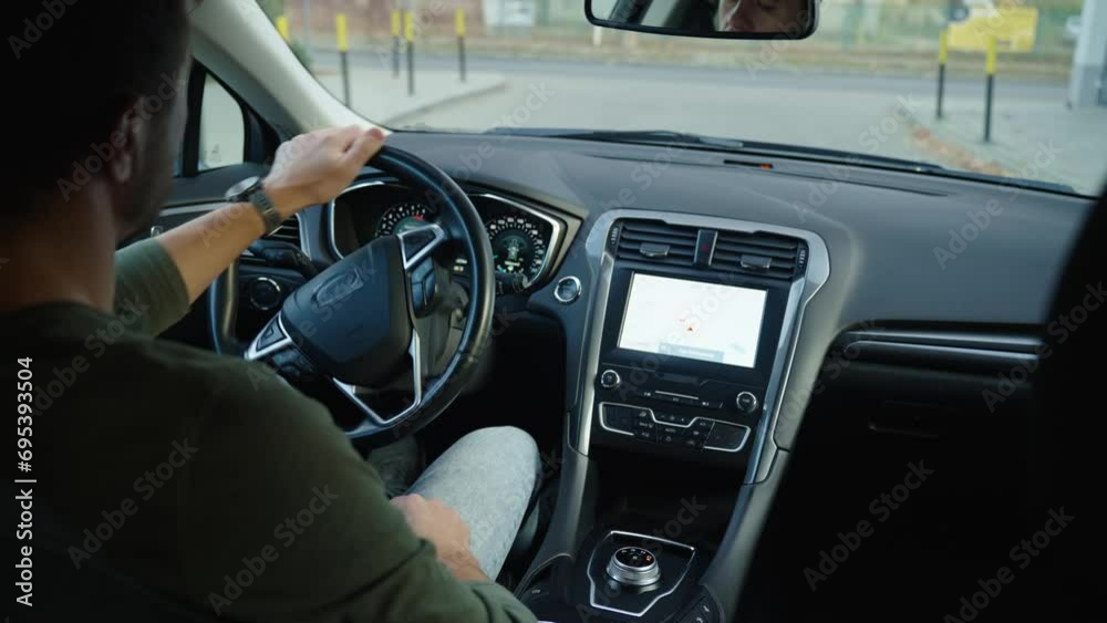 Male driver driving car, inside view. Rear view of man drives out of parking lot onto street, opens barrier with remote control