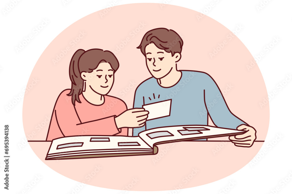 Happy couple man and woman looking at family photo album with pictures from wedding or vacation. Casual guy and girl sits at table remember past together enjoy watching photo cards. Flat vector image Happy couple man and woman looking at family photo album with pictures from wedding or vacation. Casual guy and girl sits at table remember past together enjoy watching photo cards. Flat vector image