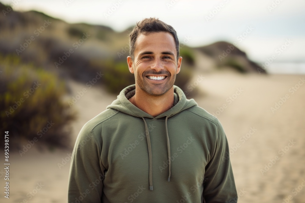 Portrait of a grinning man in his 40s dressed in a comfy fleece pullover against a sandy beach background. AI Generation Portrait of a grinning man in his 40s dressed in a comfy fleece pullover against a sandy beach background. AI Generation