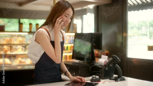 An Asian young Cashier woman working in  supermarket photo