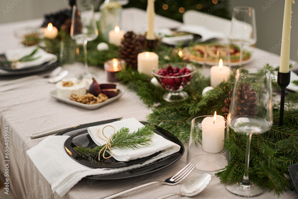 Plate decorated with fir branch displayed on festive christmas table fully prepared for celebration