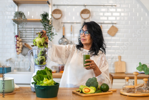 Picture of a senior woman blending a smoothie