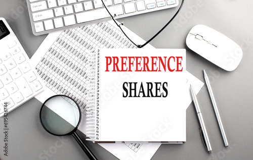PREFERENCE SHARES text on notebook with keyboard and calculator on a chart background photo