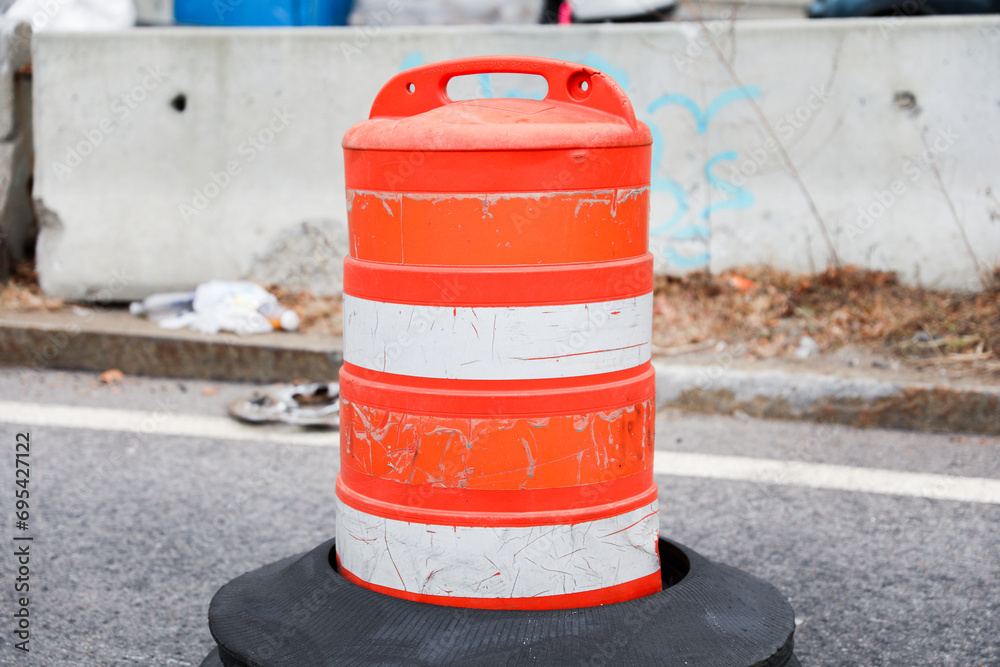 orange street construction cone on road with blurred background, symbolizing caution and ongoing work, in a stock photo orange street construction cone on road with blurred background, symbolizing caution and ongoing work, in a stock photo