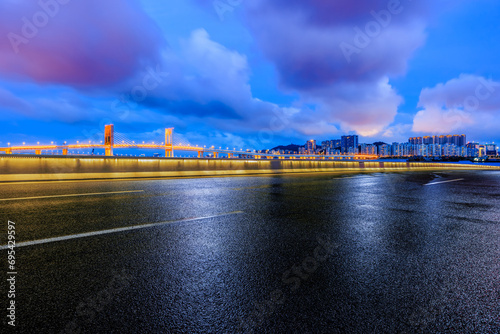Asphalt road and bridge with residential area buildings scenery at night