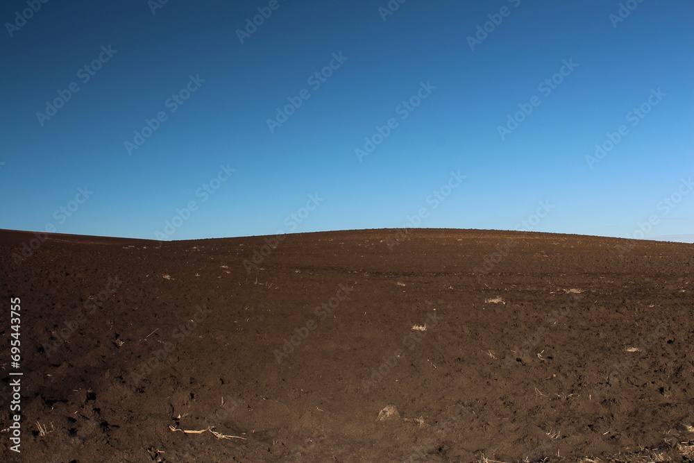 A dirt hill with a blue sky