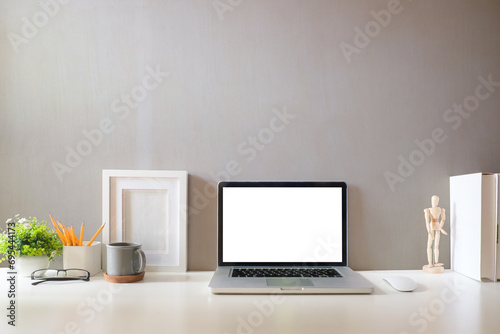 Front view laptop computer with empty screen on white table in bright room.