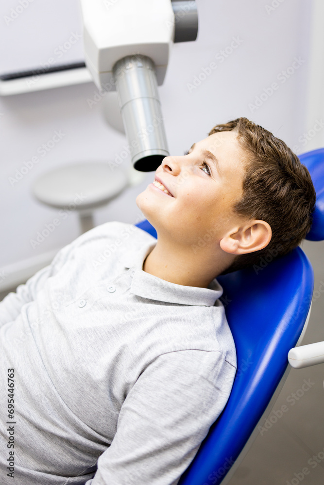 A Caucasian boy between 9 and 10 years old visits a dentist clinic to have an intraoral x-ray to identify cases of cavities,Intraoral x-ray concept. A Caucasian boy between 9 and 10 years old visits a dentist clinic to have an intraoral x-ray to identify cases of cavities,Intraoral x-ray concept.