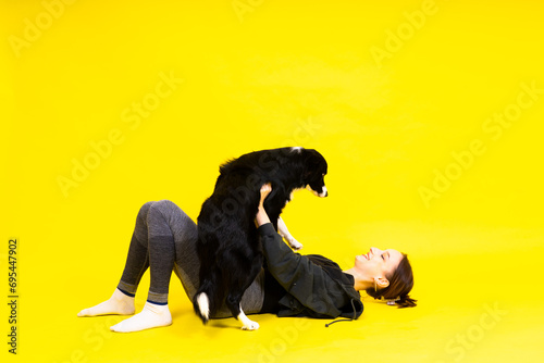Woman with cute dog border collie is in the studio. Sport with pet