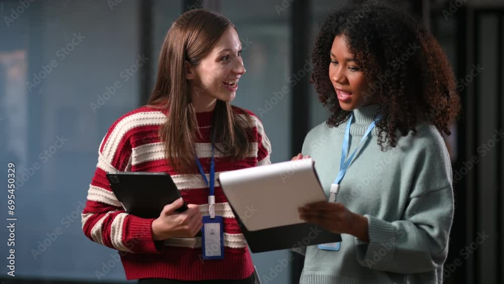 Kind leader executive manager share and discuss business solutions plan ideas on tablet with African female marketing manager in office. neon light Kind leader executive manager share and discuss business solutions plan ideas on tablet with African female marketing manager in office. neon light