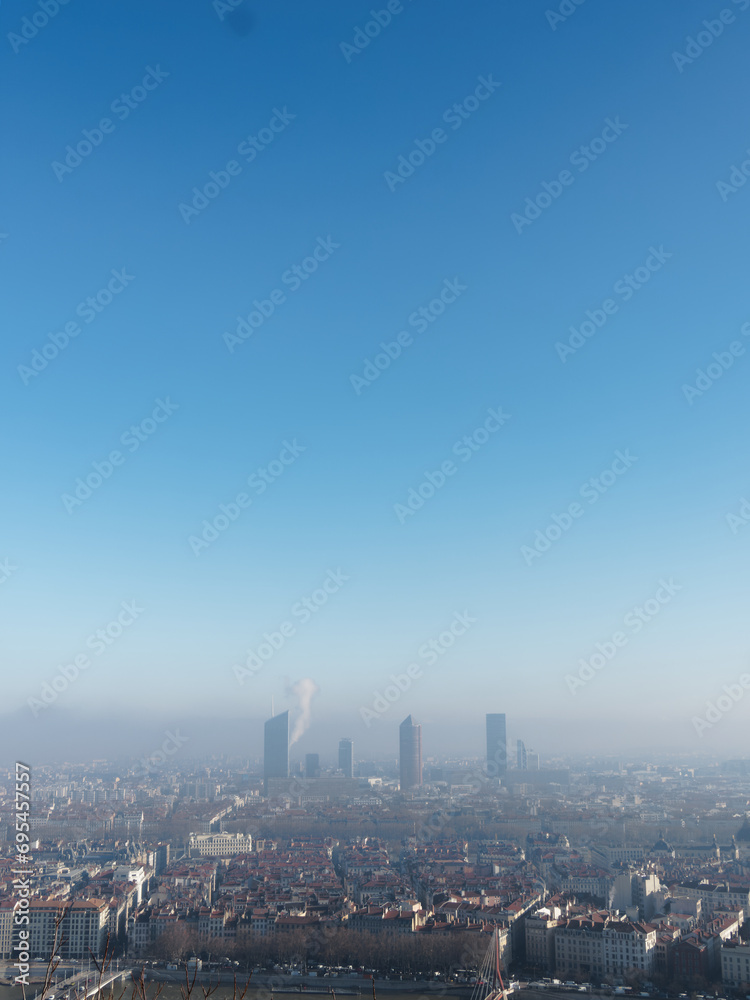 View of Lyon from Fourviere hill on a winter day, foggy polluted city and blue sky