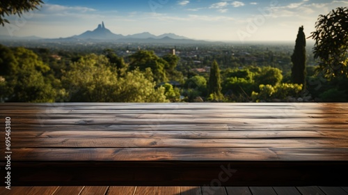  a wooden table with a view of trees and a mountain in the distance with a blue sky in the foreground and a wooden table in the foreground with a view of a.