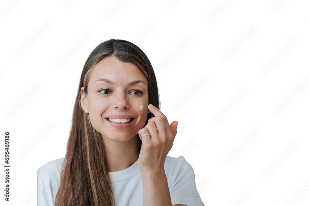 Close up portrait of pretty Italian young woman with long loose hair standing against transparent background puts skin cream on face broad smiles satisfied by skin care products Close up portrait of pretty Italian young woman with long loose hair standing against transparent background puts skin cream on face broad smiles satisfied by skin care products