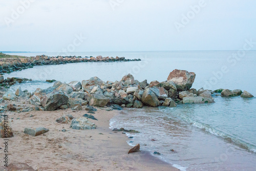 stone breakwaters on the sandy shore of the sea