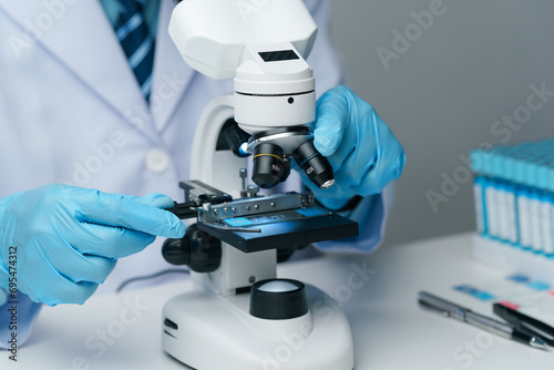 Scientists conducting research investigations in a medical laboratory. Scientist wearing medical gloves nanotechnology, research, fiber, microbiology, glass, test tube, medicine photo