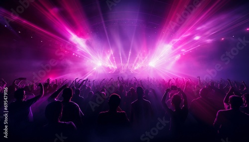 Silhouettes of dancing crowd in front of a bright stage lights