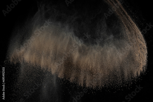 Soil explosion on black background. Abstract texture. Cloud of brown ground. Sand explode. 