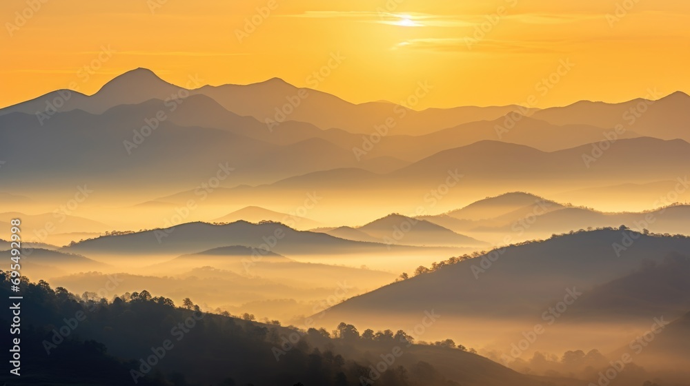 The sun is setting over a mountain range. Misty mountains on a sunset or dawn.