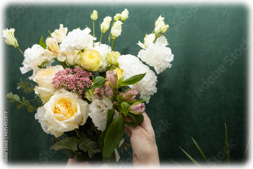 Floristry. Flowers. A florist girl collects a bouquet of white and yellow roses. Blurred background.