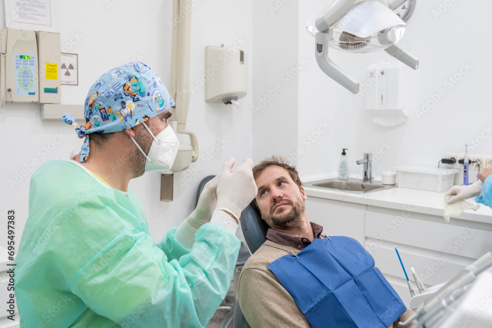 A patient undergoing a dental check-up in a clinic with the dentist in attendance and all the tools of dental care. A patient undergoing a dental check-up in a clinic with the dentist in attendance and all the tools of dental care.
