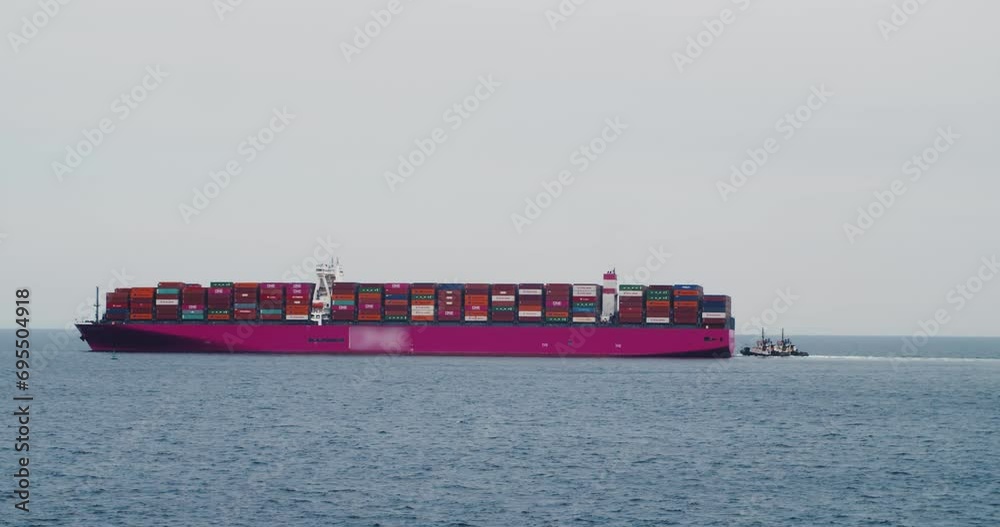 Container cargo ship on the ocean, accompanied by tugboats, entering Halifax. Container cargo ship on the ocean, accompanied by tugboats, entering Halifax.