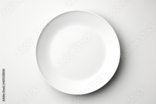 A white plate on a table with a fork and knife.