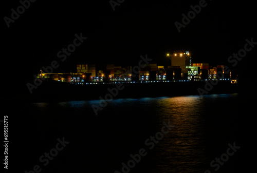The container ship standing on an anchor at night.