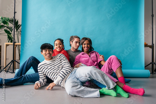 Group of four friends sitting together in studio, relaxed and connected photo