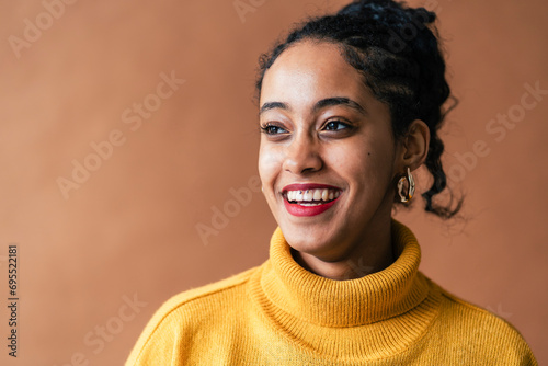 Woman in a mustard turtleneck beams with a bright, captivating smile photo
