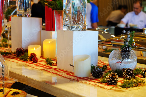 Candles and conifer fruit decoration on Christmas event in a dining place
