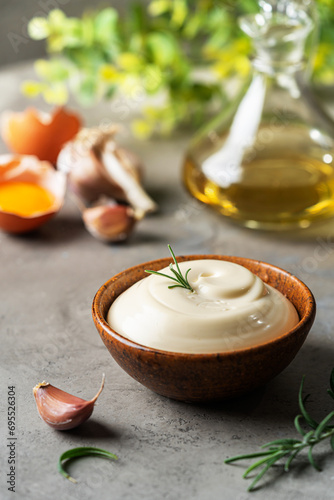 Bowl of Homemade mayonnaise sauce with ingredients and herbs for cooking photo