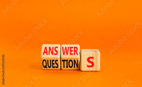 Q and A questions and answers symbol. Turned wooden cubes and changed the word questions to answers. Beautiful orange background, copy space. Business Q and A questions and answers concept. photo