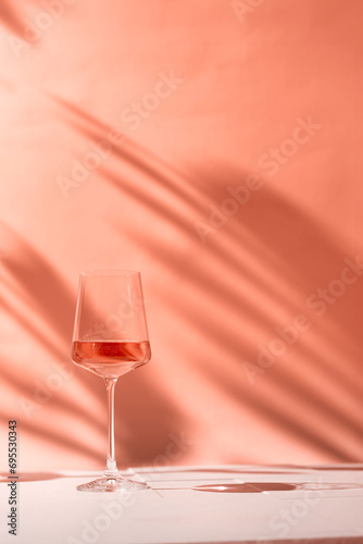Glasses with rose wine or champaign on peach fuzz color background. Color of the year 2024 concept. High quality photo
