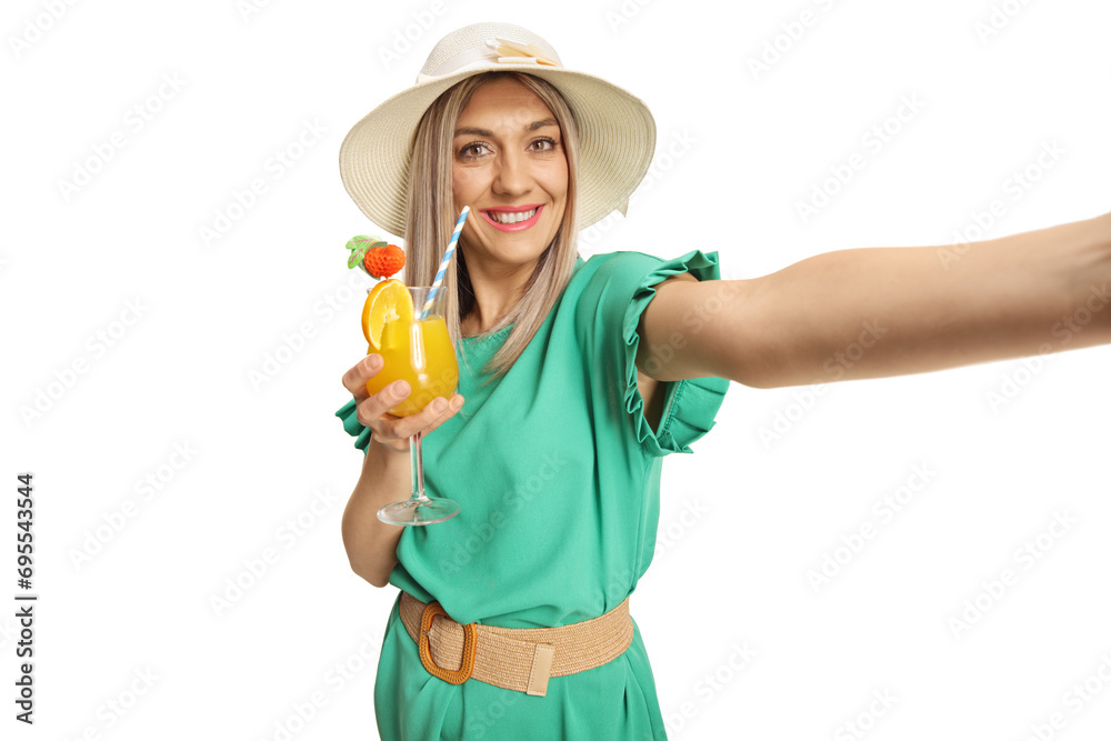 Beautiful young woman in a green dress holding a cocktail and taking a selfie Beautiful young woman in a green dress holding a cocktail and taking a selfie