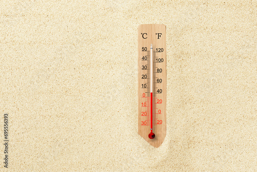 Hot summer day. Celsius and fahrenheit scale thermometer in the sand. Ambient temperature plus 5 degrees