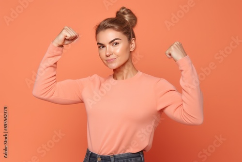 strong woman with fist up demonstrates power. confident lady demonstrating her strength by roll up her sleeve. Girl power photo