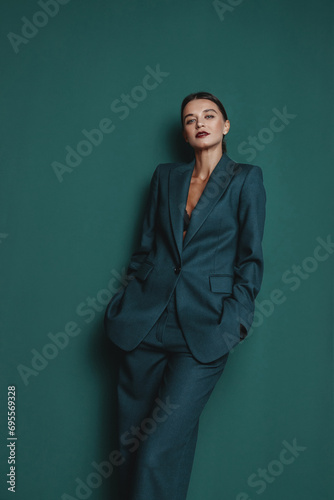 Fashionable confident woman wearing elegant green suit