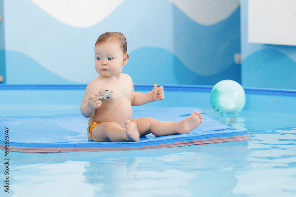 Portrait happy baby girl in swimming pool, teaching small swimmer. Concept healthcare sport for infant Portrait happy baby girl in swimming pool, teaching small swimmer. Concept healthcare sport for infant