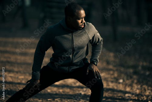 Male athlete doing stretching exercises in a park