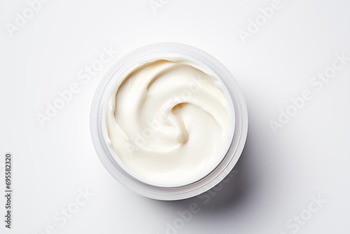 Cosmetic cream in open jar on a white background. Top view
