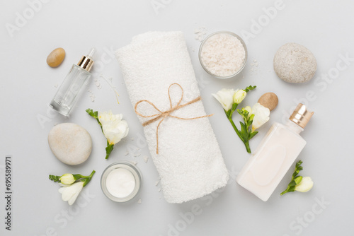 Flat lay with spa products and flowers on color background