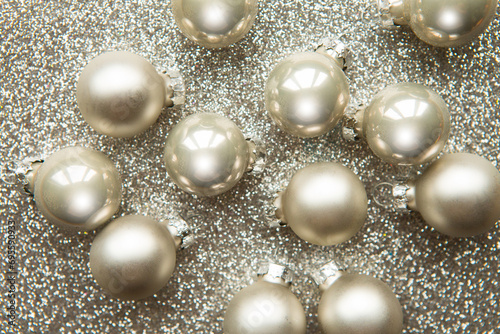 Silver Christmas baubles on silver glitter background