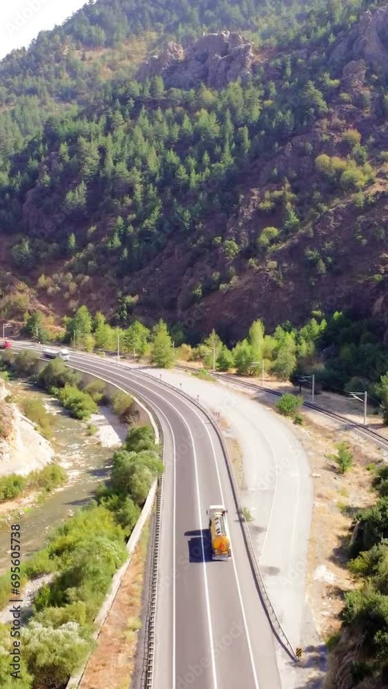 Aerial road trip view, mountain highway in summer. Road trip adventure, wanderlust in mountainous terrain. Wanderlust road trip, highway snakes through mountains, aerial view Aerial road trip view, mountain highway in summer. Road trip adventure, wanderlust in mountainous terrain. Wanderlust road trip, highway snakes through mountains, aerial view
