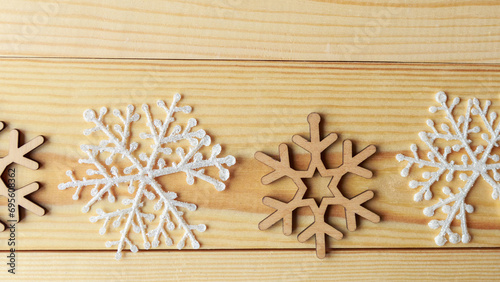 White and wooden snoflakes on wooden background. Christmas abstract background