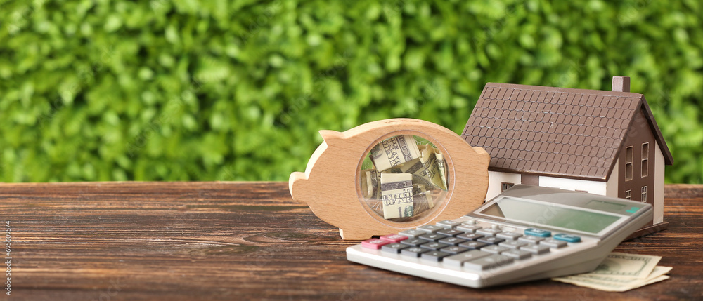 Φωτογραφία Calculator, model of house and piggy bank with money on wooden table outdoors