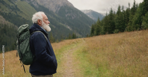 Elderly man with bearded face, representing wisdom and happiness, enjoys fresh air in nature.