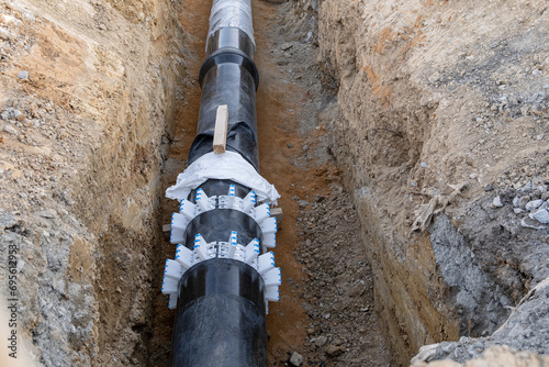 Digged heating pipes in a construction site. Install underground heating system of apartments , water main or sanitary sewer.