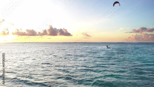Sunset sky over the Indian Ocean bay with kiteboarders riding kiteboards with green bright power kite. Active sport people and beauty in Nature concept image. Le Morne beach, Mauritius 4K video. photo